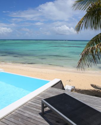 Infinity,Pool,With,Deck,Chair,By,The,Beach